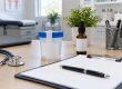 Recipiente de prueba y frasco sin etiqueta sobre una mesa clínica
