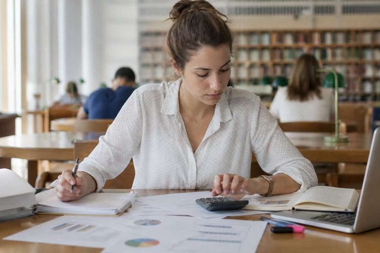Estudiante de Administración de Empresas analizando un caso con gráficos y notas