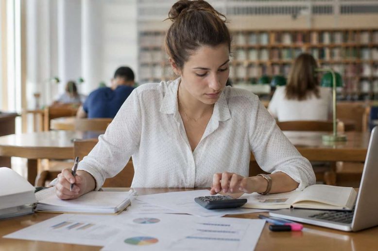 Estudiante de Administración de Empresas analizando un caso con gráficos y notas